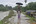 Een jongen probeert zichzelf droog te houden met een paraplu. Ze wandelen over een modderig pad in India, op 22 juli 2020.